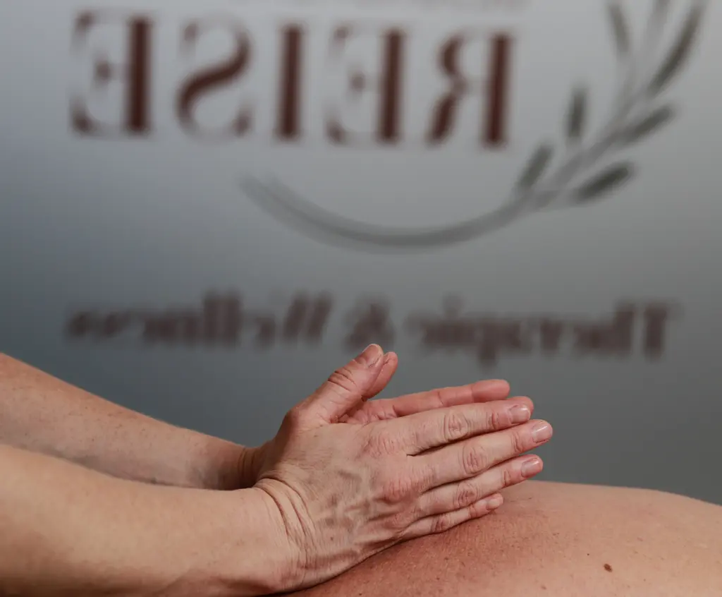 Reiki-Therapeutin legt die Hände sanft auf den Oberkörper einer liegenden Person zur Energiearbeit und Entspannung